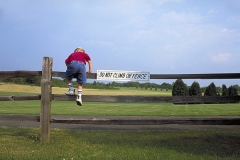 boy climbing fence